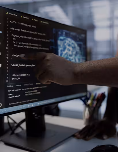 Écran d’ordinateur affichant du code avec une main pointant une ligne, illustrant le service de maintenance technique chez Keiyo