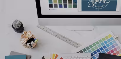 Deux personnes choisissant des échantillons de couleurs sur une table, représentant la conception graphique pour supports imprimés