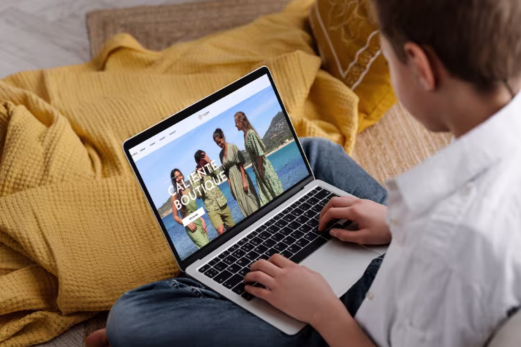 Page d’accueil du site de la Boutique Caliente affichée sur un ordinateur portable avec une
