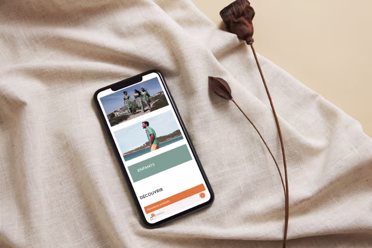 Site d'Ananda affiché sur écran mobile posé à côté d'une rose sèche